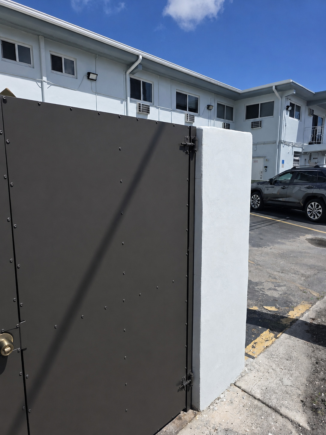 Angled exterior view of the completed solid-panel dumpster enclosure